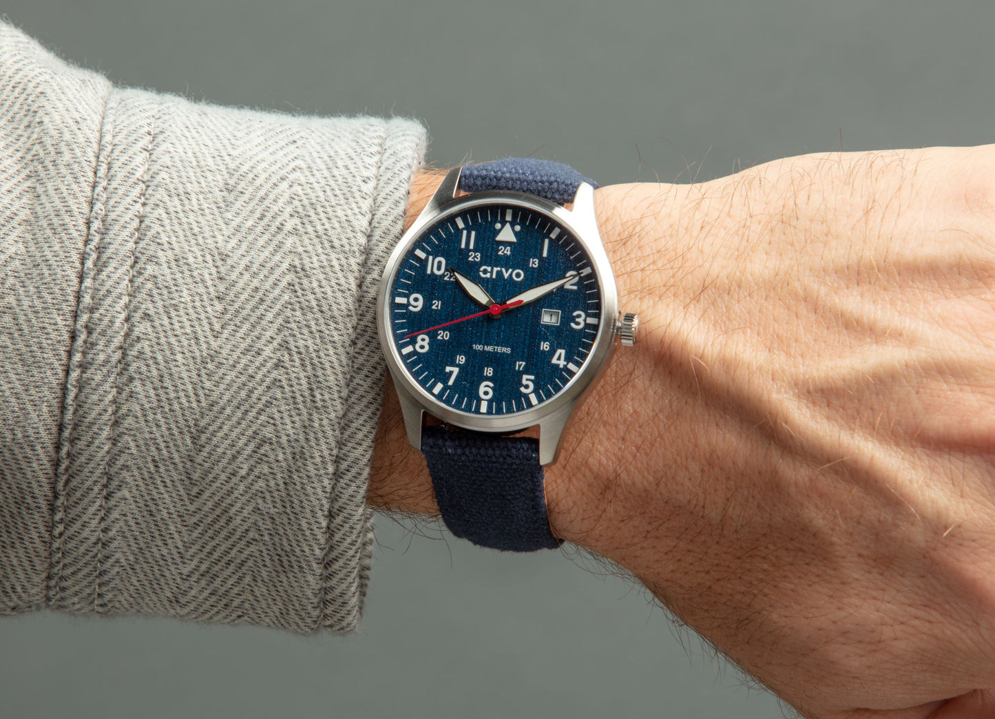 Arvo Rove Field Watch for men with a jeans blue dial and blue canvas strap on a wrist with a khaki sleeve