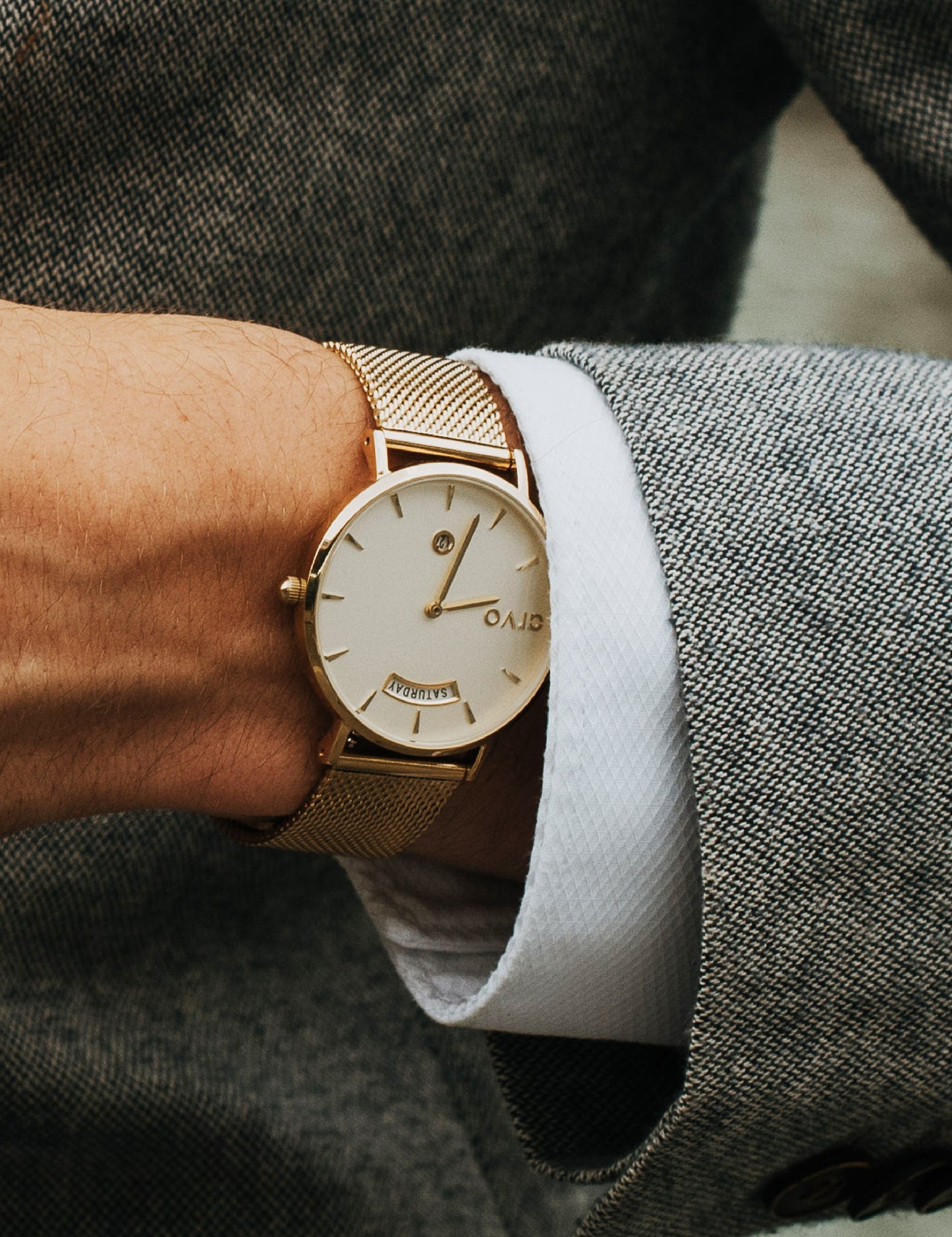 Mans wrist wearing an Arvo Awristacrat gold watches for men and women gold mesh band