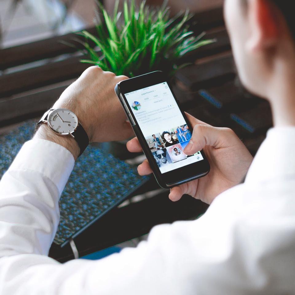 man checking his Arvo Awristacrat silver with black leather classic watch for men and women while looking at his phone