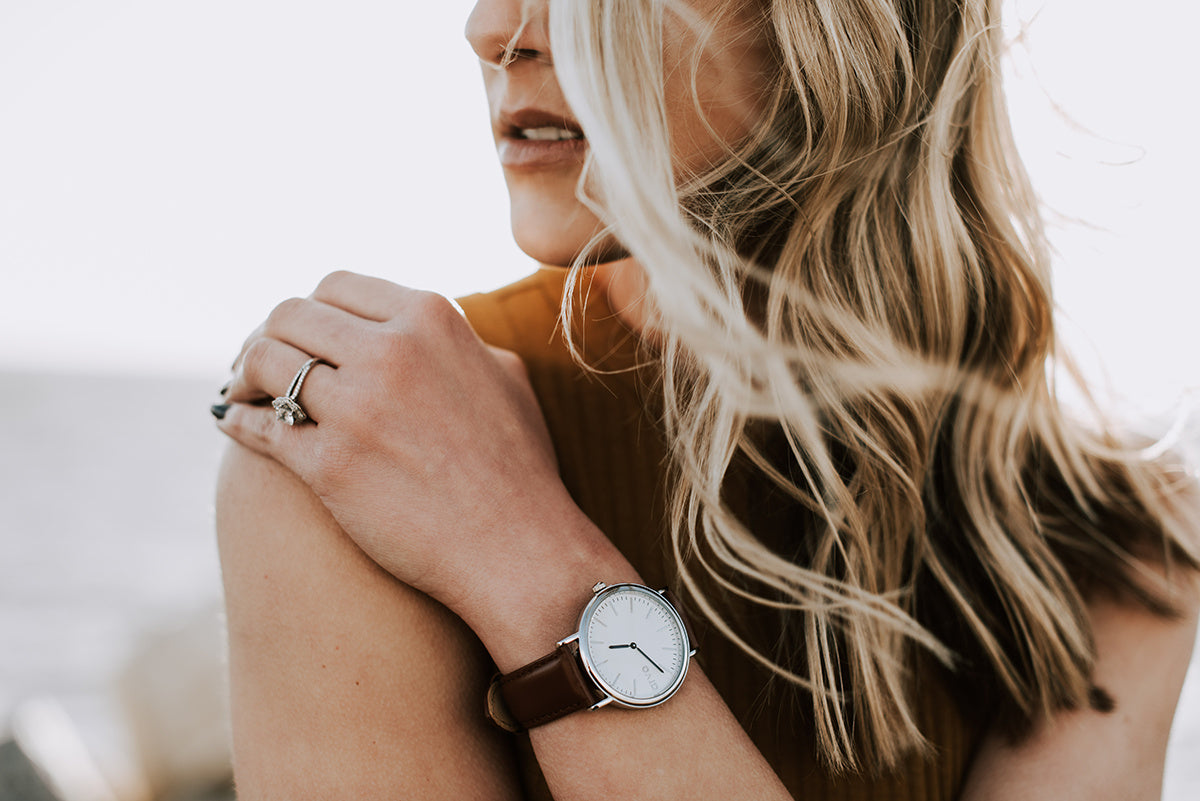 Woman wearing a Time Sawyer Watch for men and women with white dial, silver case and brown leather band