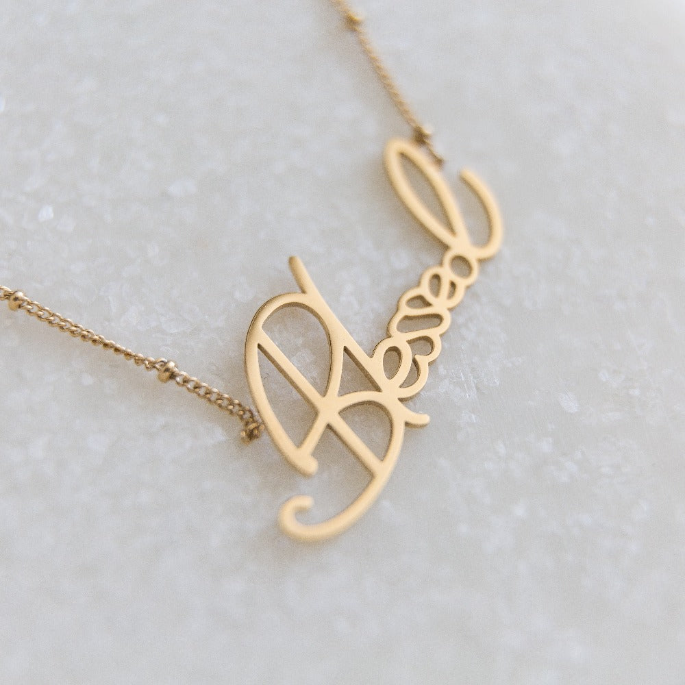 closeup of an Arvo gold blessed necklace on a white background
