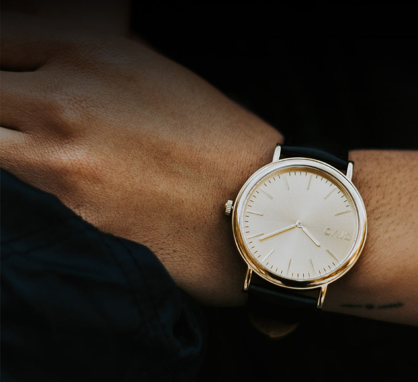 Arvo Gold Time Sawyer Watch with a black stitched band on a woman's wrist