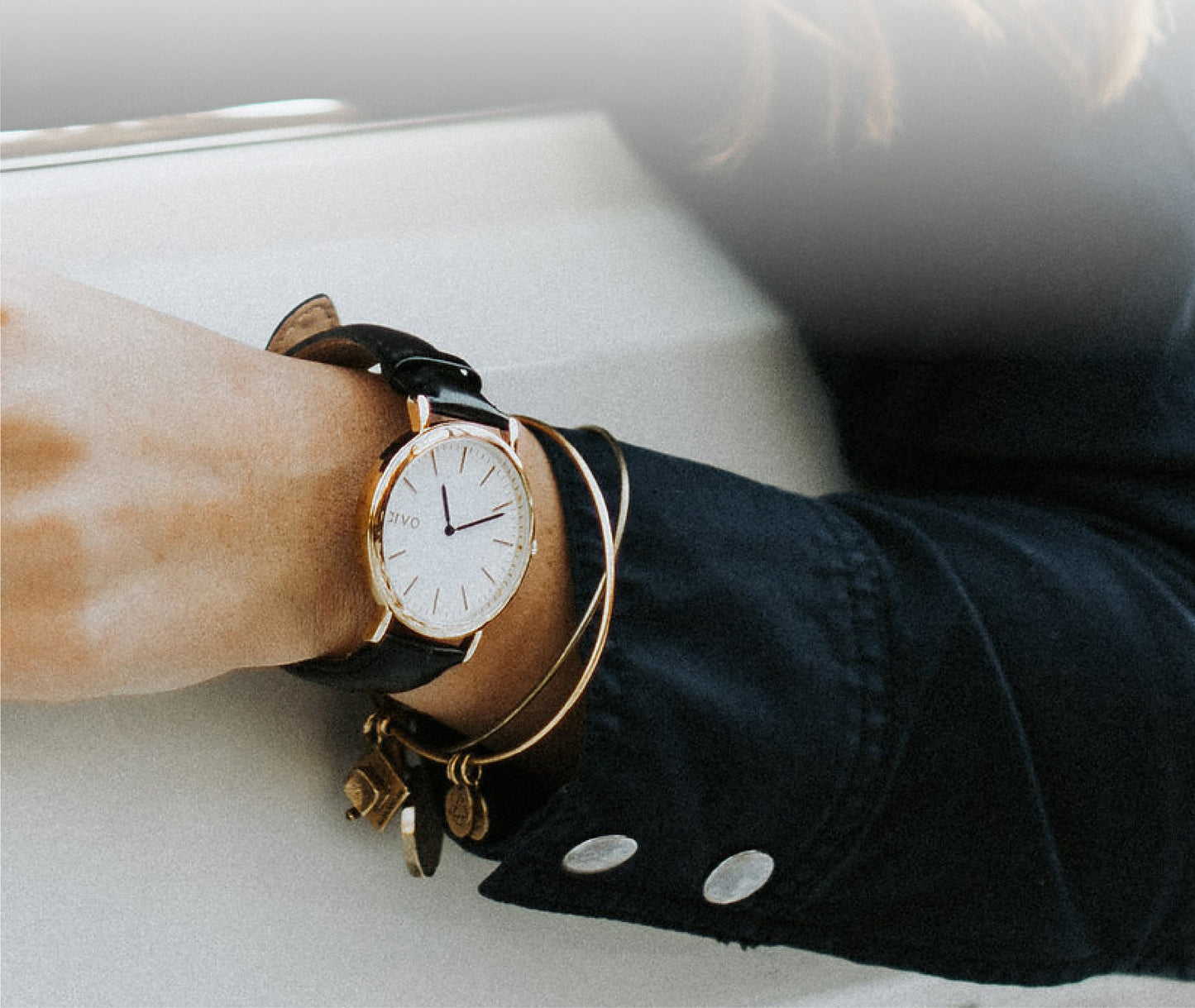 Arvo Time Sawyer Watch with white dial, gold case, and black leather band on a woman's wrist