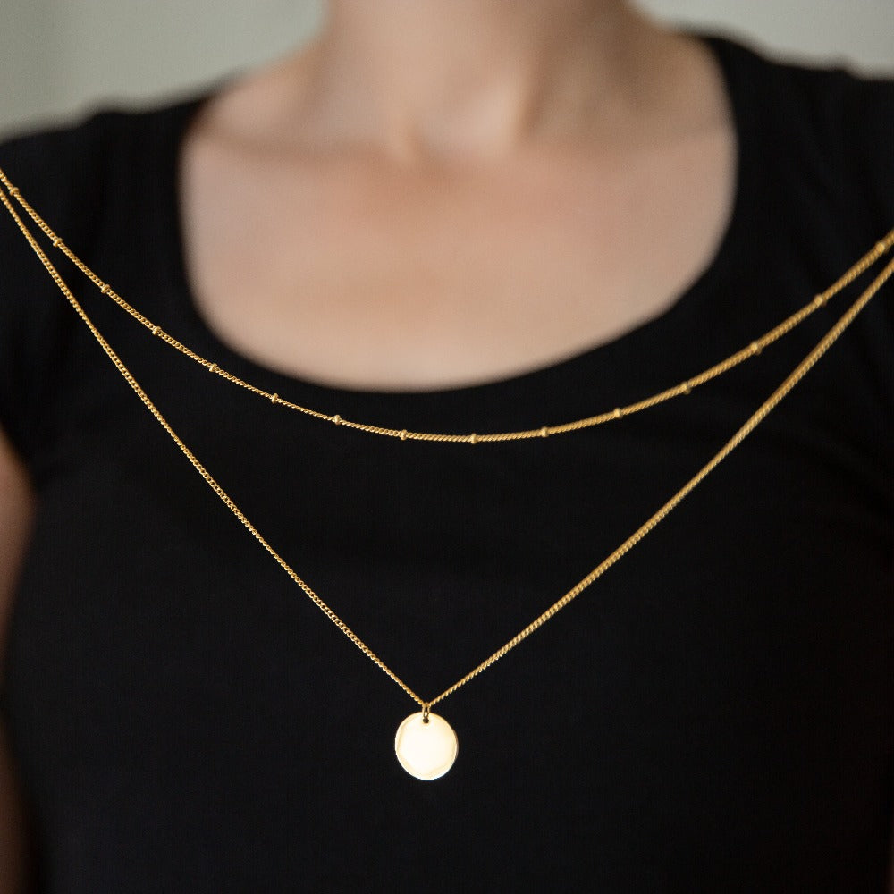 Woman holding Arvo Layered Disc Necklace